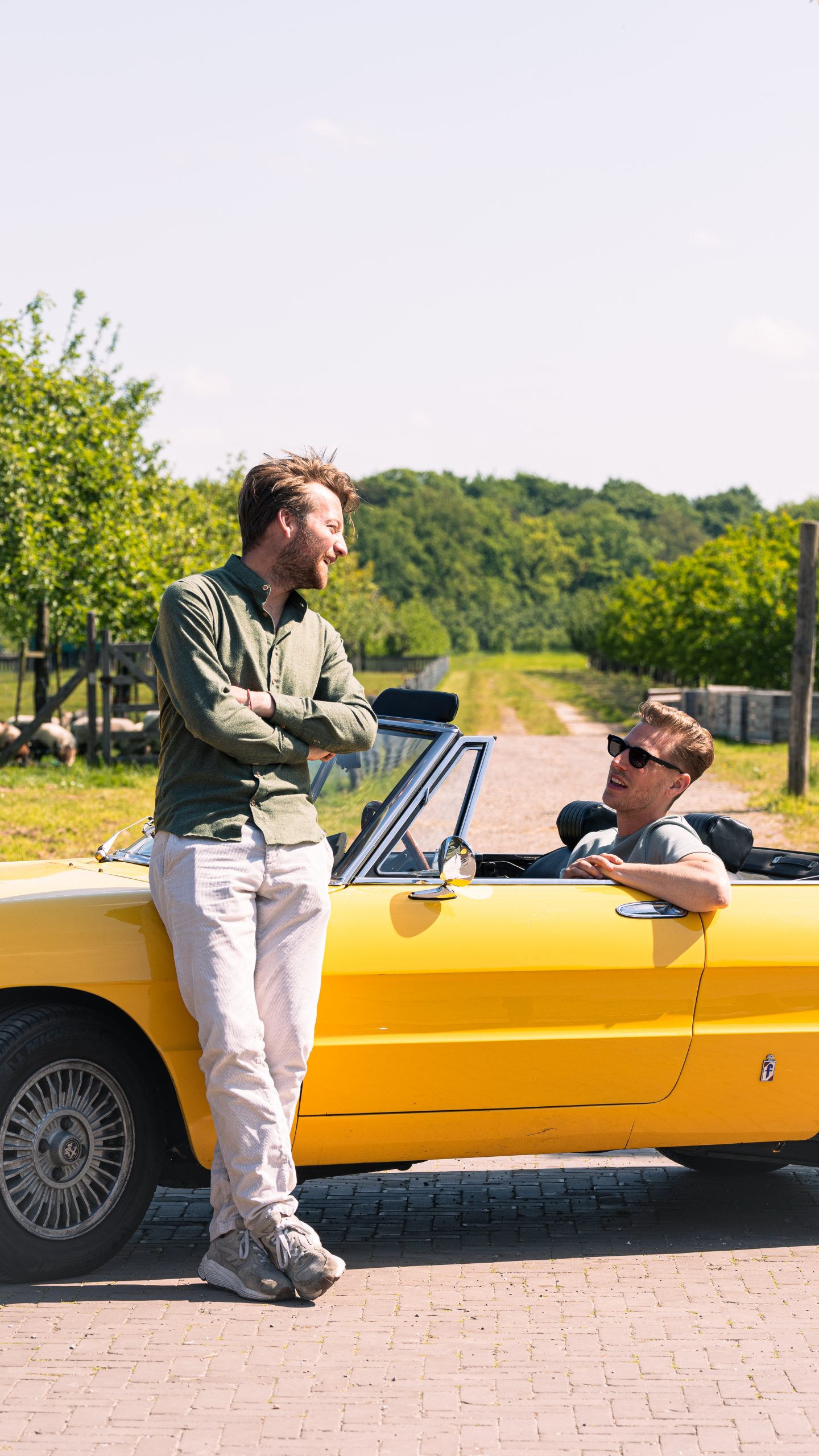 Harrie en Nick, oprichters van Che Dona Luce, bij een gele cabrio